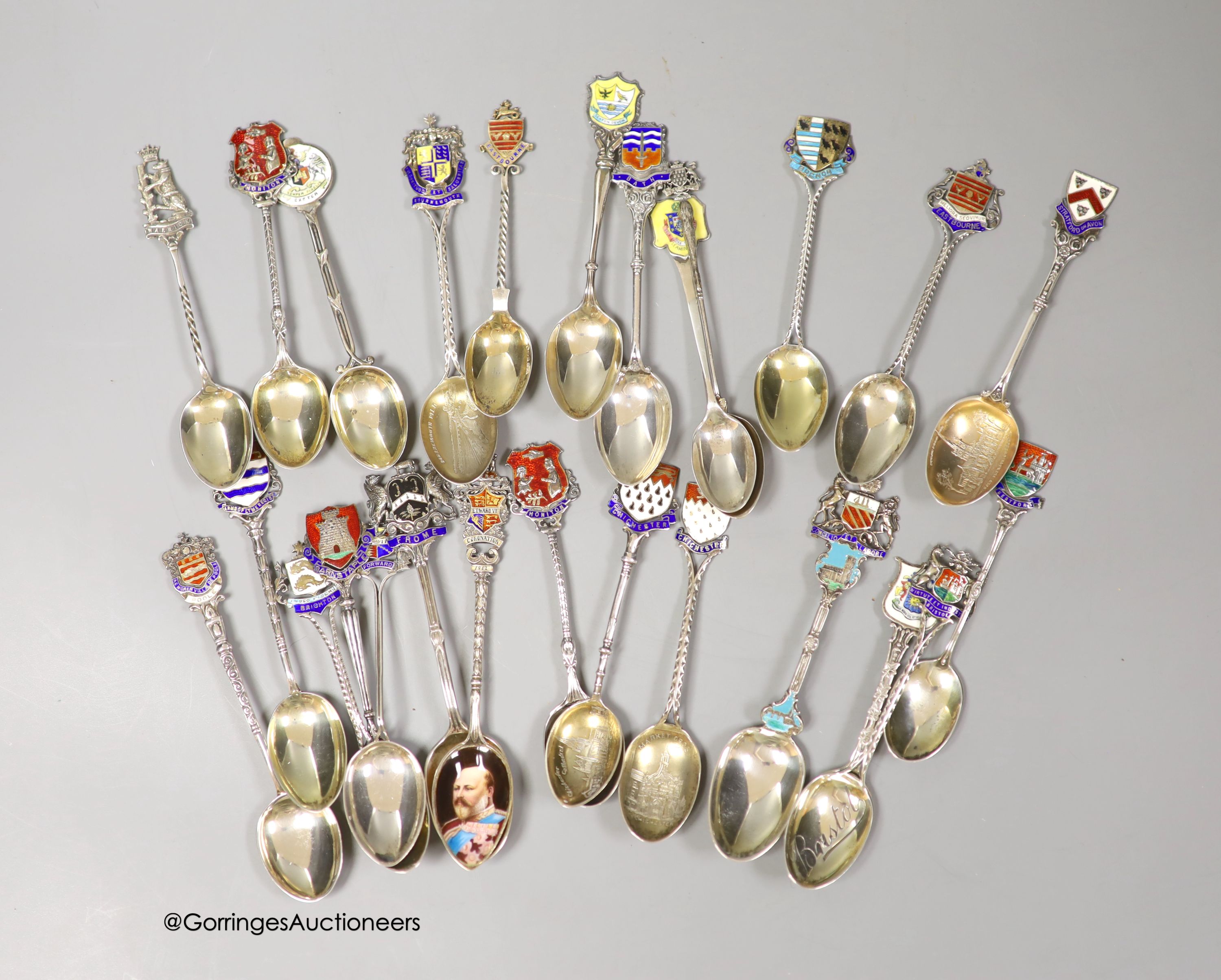 Twenty five assorted 20th century silver and enamel souvenir spoons, including Brighton, Bournemouth, Eastbourne, Chichester etc. and and Edward VII Coronation spoon, together with a similar white metal spoon, gross weig